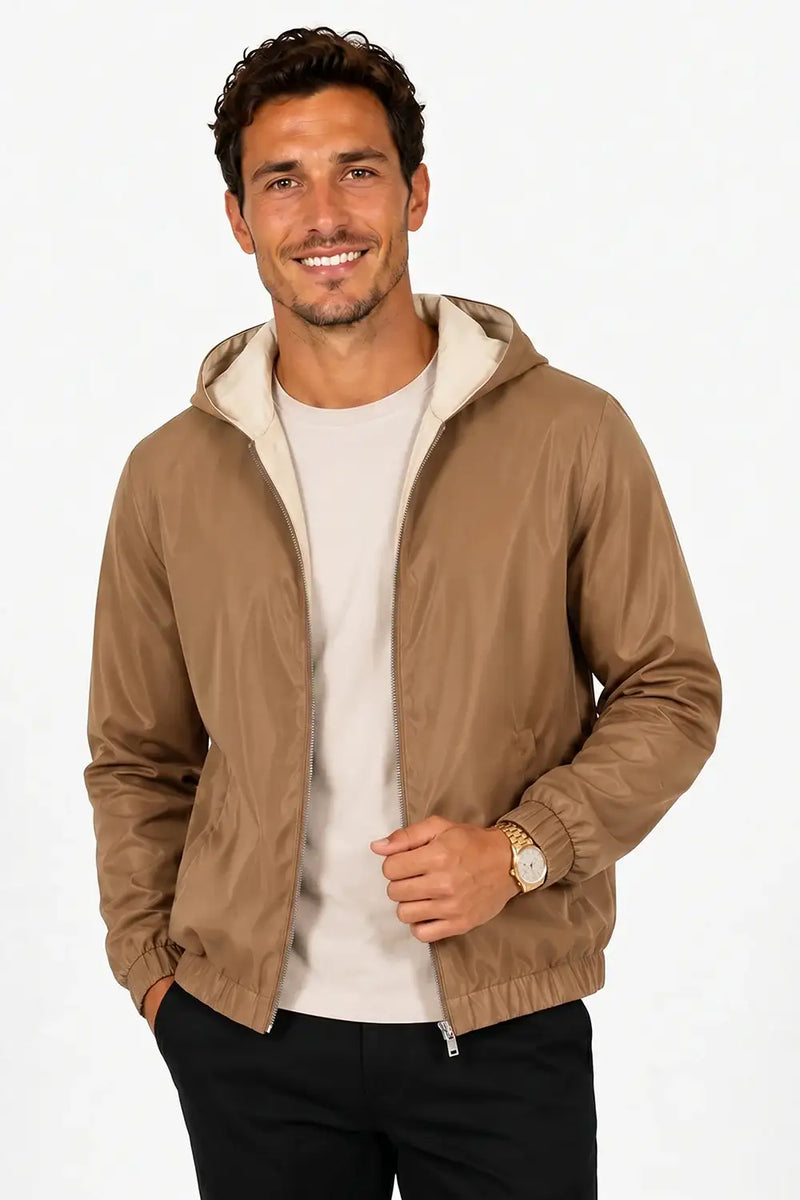 Man wearing tan hooded bomber jacket with zipper, paired with black pants and white tee for casual style